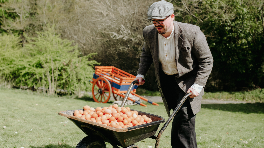 a man wheeling a basket of eggs 