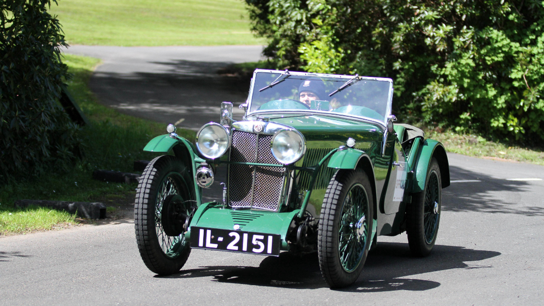 A green car driving up the steep hill in Cultra