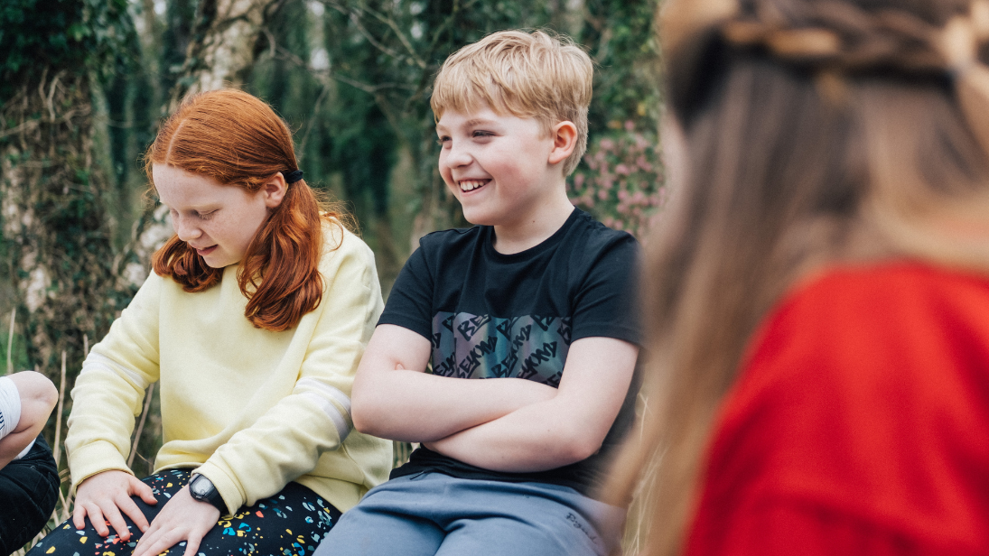 Two children laughing sitting on the wall at the Ulster Folk Museum