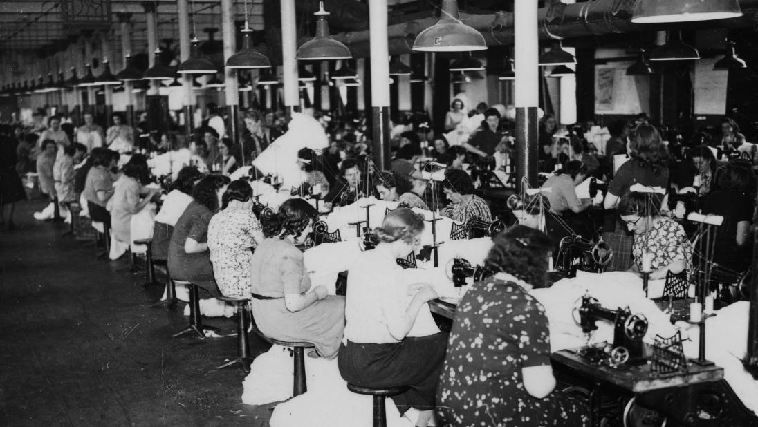 Female workers at sewing machines making parachutes