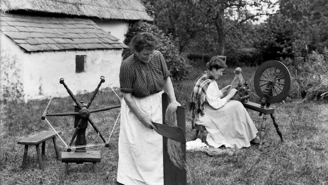 Ladies scutching flax outside