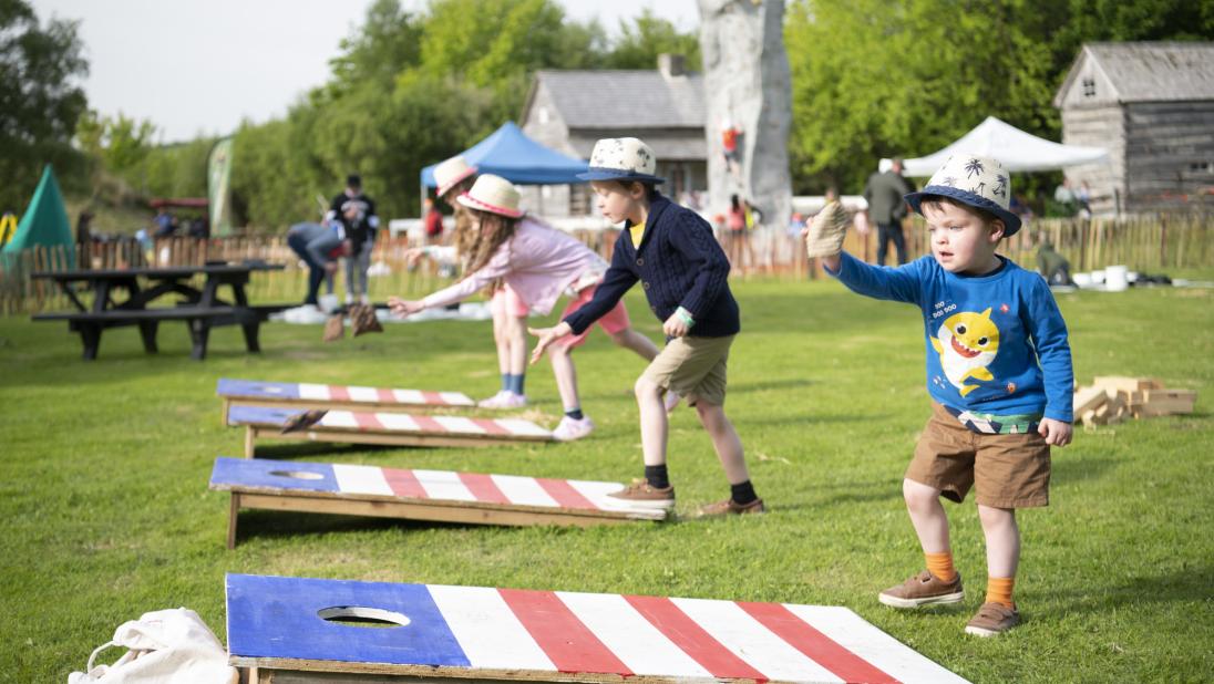 Young kids playing cornhole