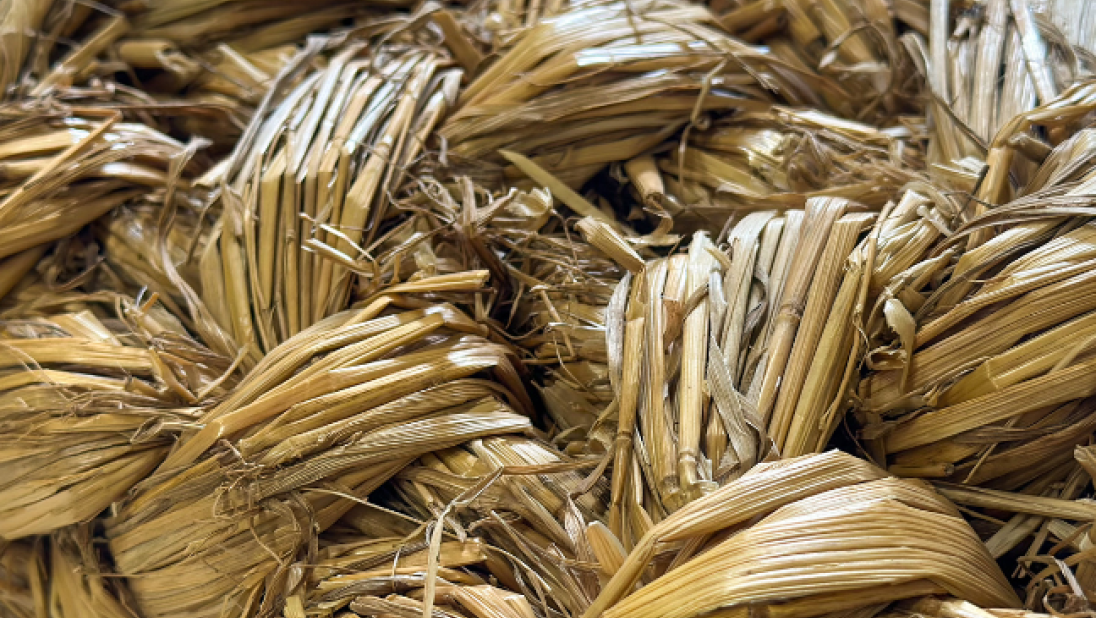 Close-up of a woven mat with hay-like material.