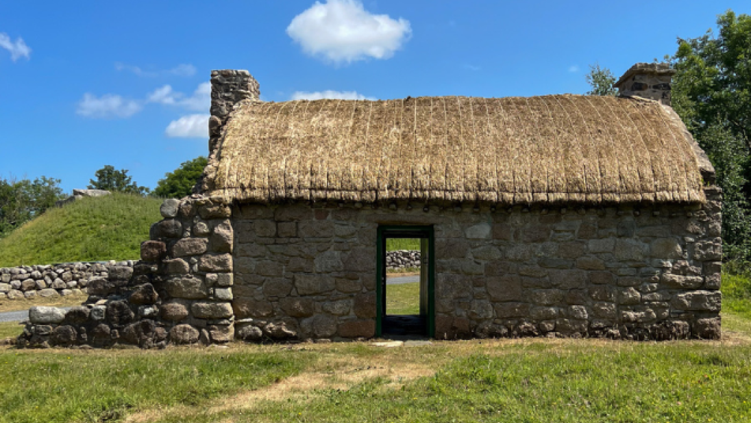 A byre dwelling with its two doors open, so that you can see from one side of the cottage through to the other.