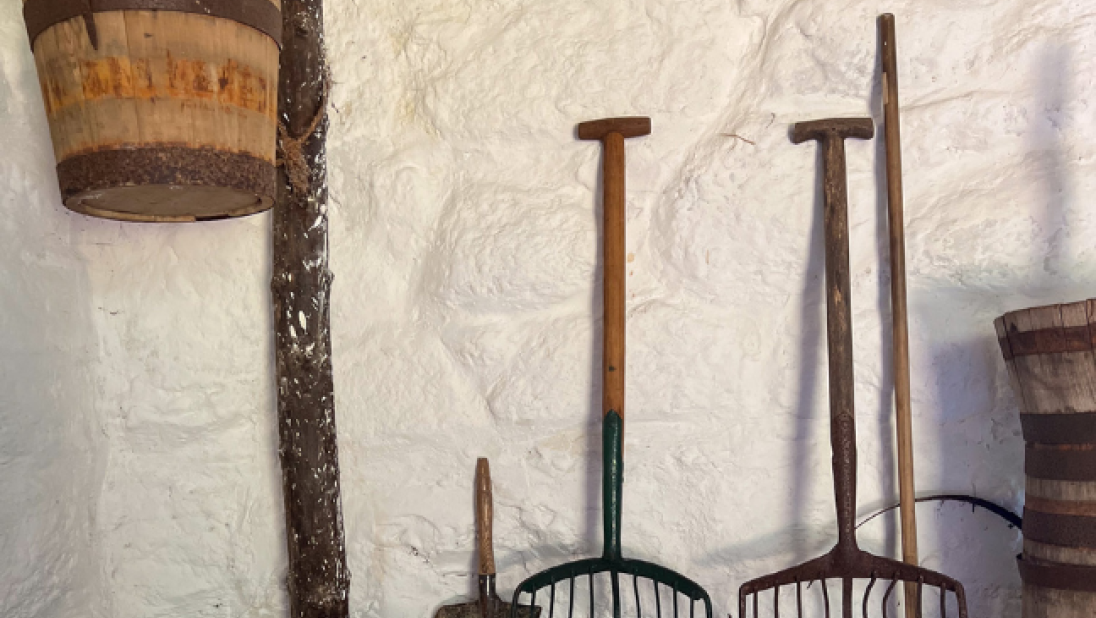 A scene inside a byre dwelling of farming tools.