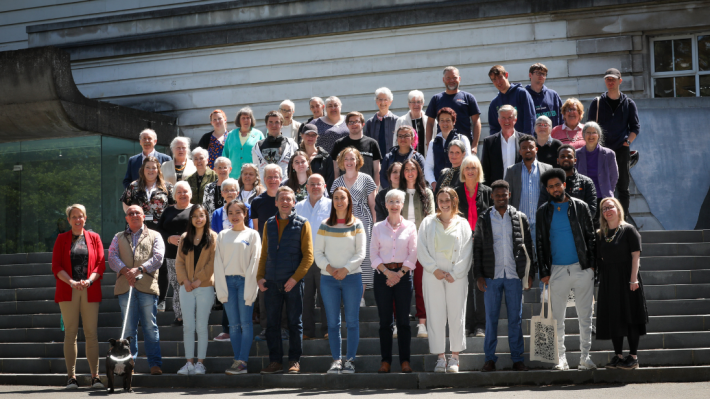 Group of people, all volunteers with National Museums NI, standing on steps out the front of Ulster Museum at a Volunteers' Week 2022 event
