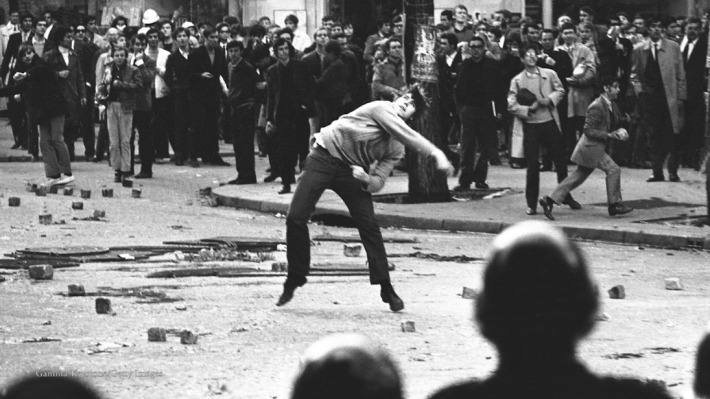 Voices of 68, black and white photograph, big crows on the street, man throwing