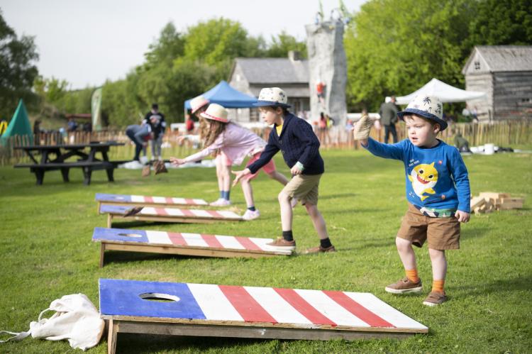 Young kids playing cornhole