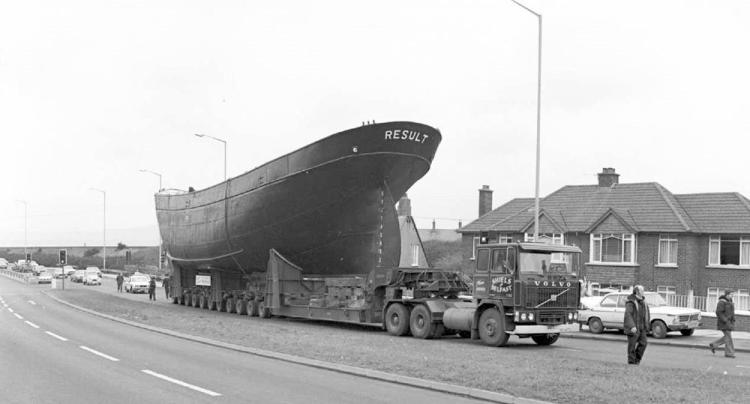 Result halts on the road to allow the removal of overhead cables so she can pass.