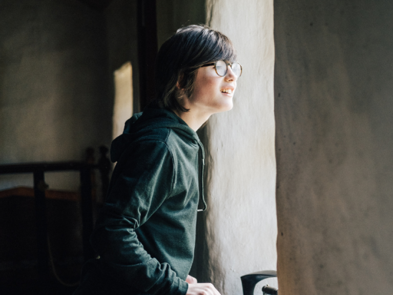 Young boy looking out of a window, Ulster American Folk Park