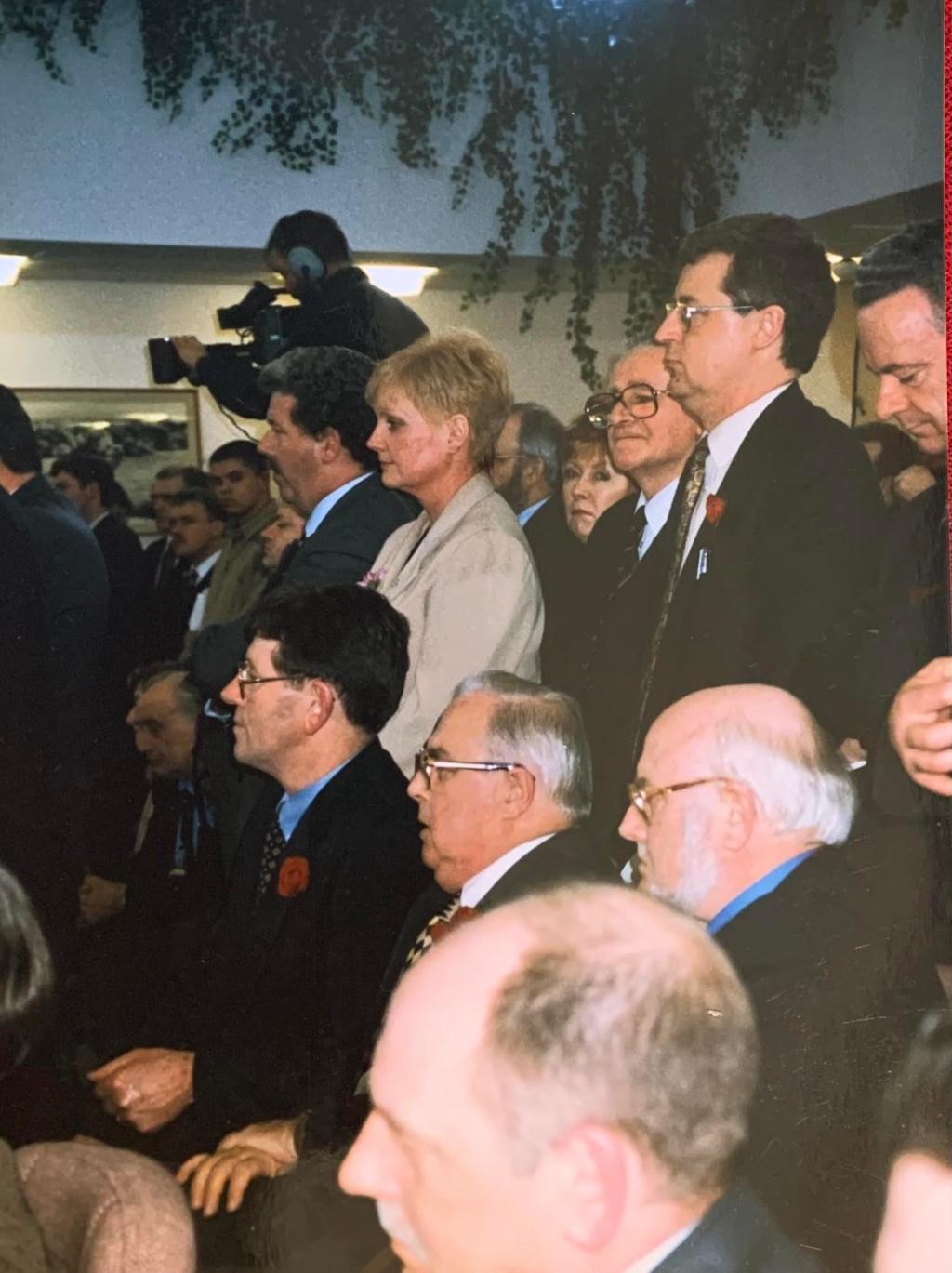 Photograph taken by Jane Morrice at the signing of the Belfast/Good Friday Agreement. One woman standing in the middle of a group of men.